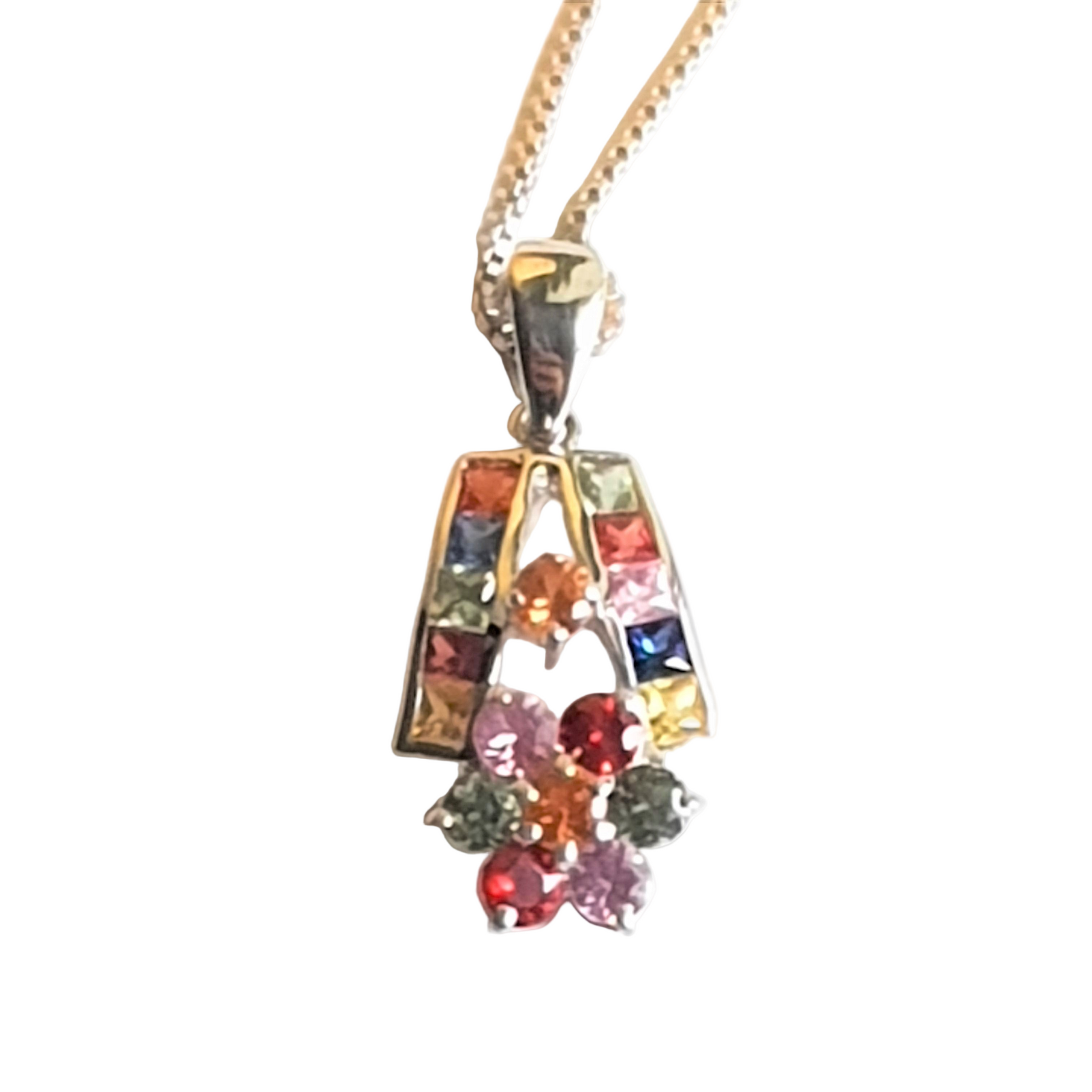 Detailed close-up of rhodium-plated pendant with multi sapphire stones, showcasing the intricate setting and radiant hues.