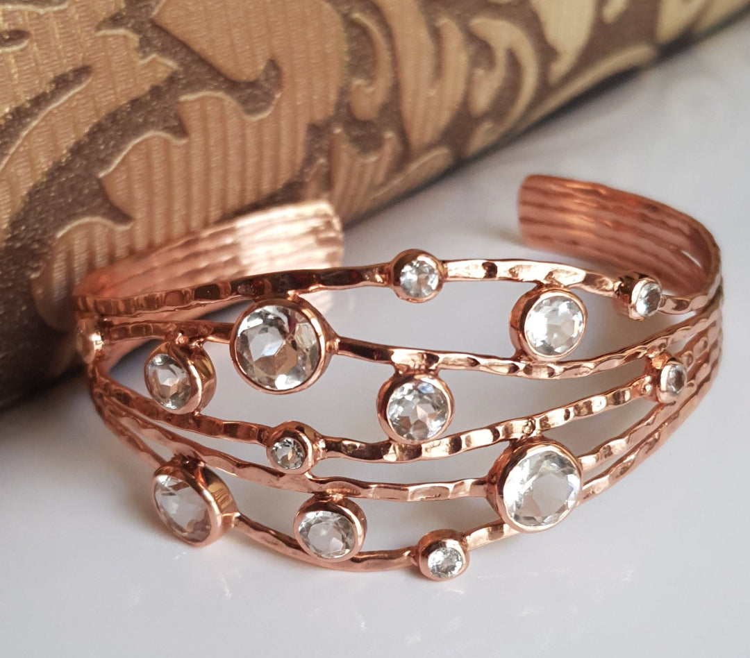 Office party wear jewellery Rose gold bracelet with clear stones on a textured surface