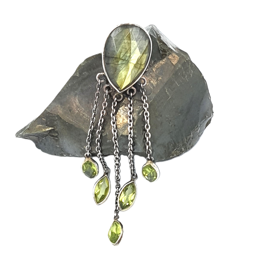 Close-up of sterling silver earrings featuring labradorite and peridot stones, highlighting their iridescent colors and detailed craftsmanship.