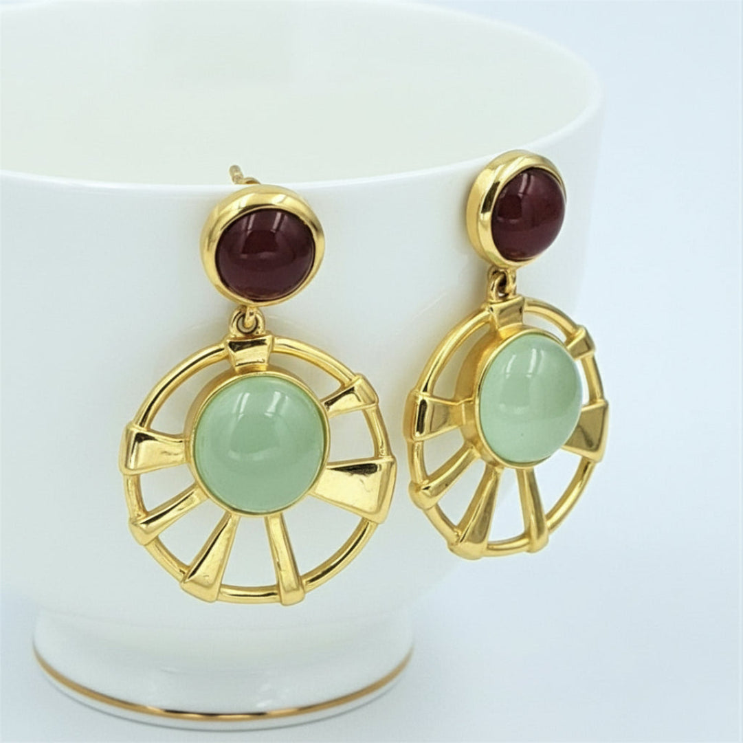 A pair of round earring featuring a red onyx stone and a green prehnite chalcedony, both set in gold-colored mountings.