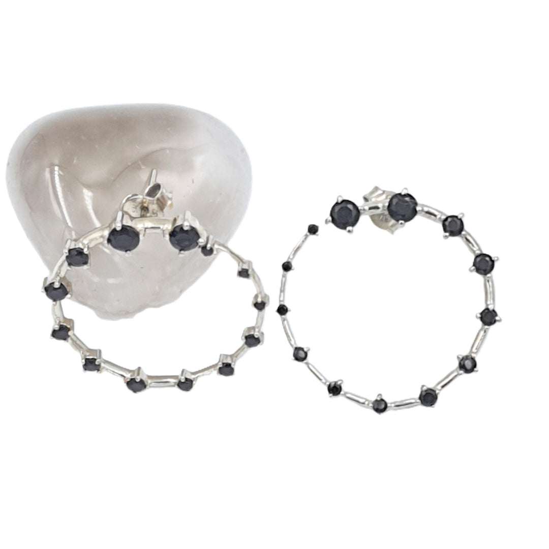 Rhodium-plated 92.5 sterling silver hoop earrings with black onyx stones, showcasing their sleek contemporary design.