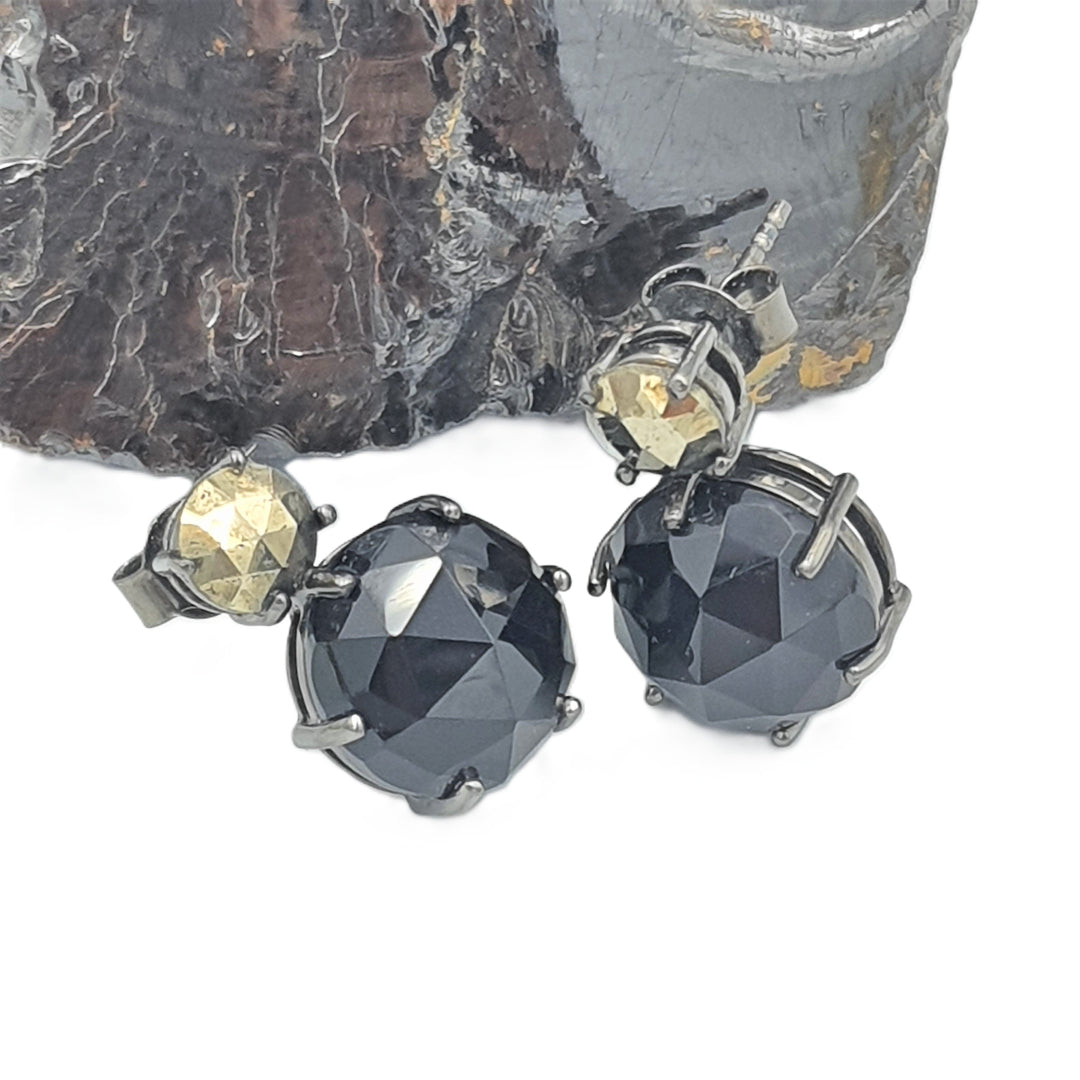 Close-up of black oxidized silver earrings with pyrite and black onyx gemstones, showcasing the detailed craftsmanship.