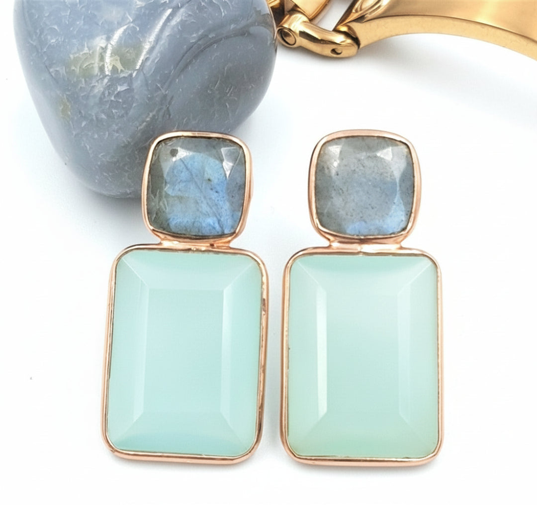 A pair of 925 silver earrings featuring octagonal cut Labradorite and rectangular cut Aqua Chalcedony stones, with a rose gold finish on a white surface.