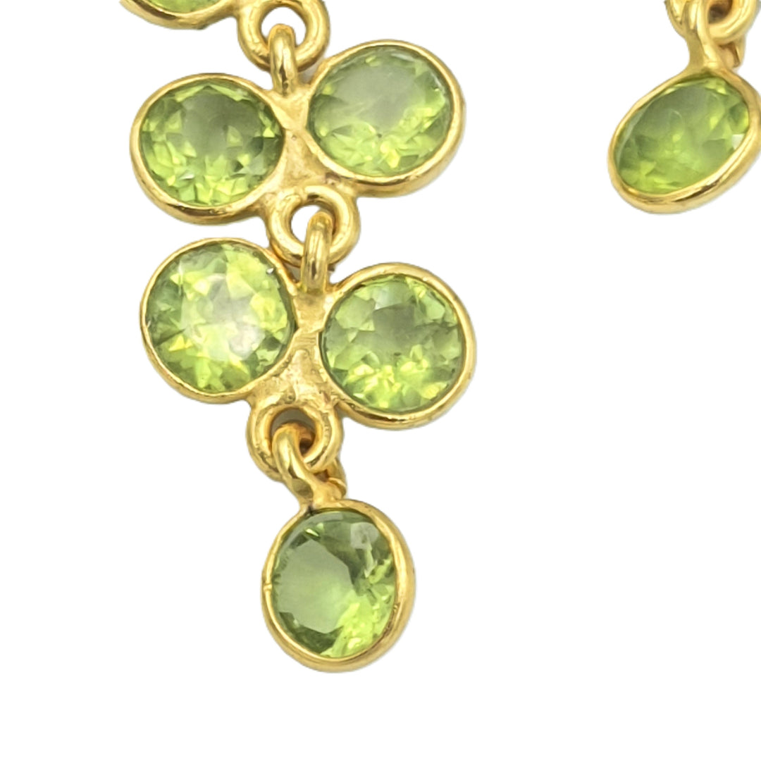 Close-up of peridot gemstone earrings in 925 sterling silver with yellow-gold plating, showing the wisteria-inspired floral design.