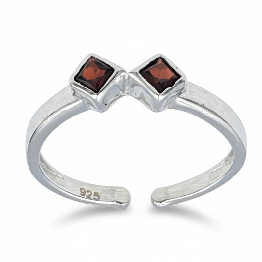 An adjustable finger ring with a rhodium finish, featuring garnet stone accents on a silver band. The ring is inscribed with '925'.