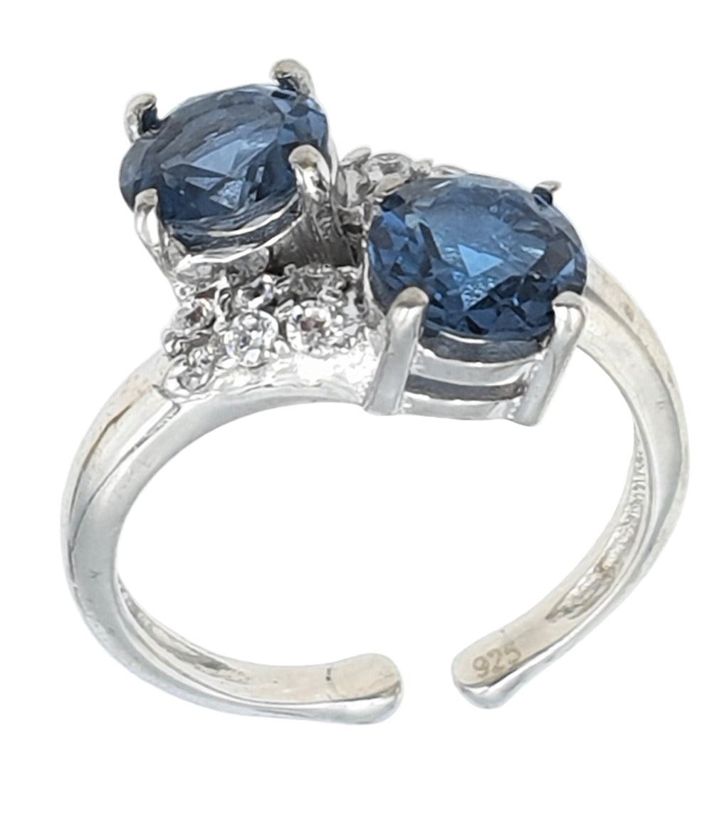 Silver ring with two blue topaz gemstones on a white background