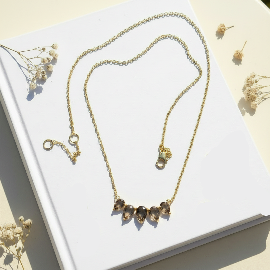 Gold-plated smoky quartz necklace showcasing its soft brown shimmer and elegant dewdrop-inspired arrangement.
