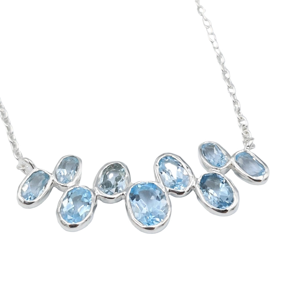 Close-up of blue topaz necklace in 92.5 sterling silver, highlighting the vibrant lagoon-blue gemstones.