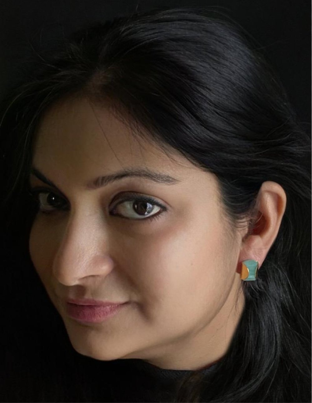 Amazonite stud earrings in yellow-gold plated 92.5 sterling silver worn by a woman, showing their sleek, professional look when styled.