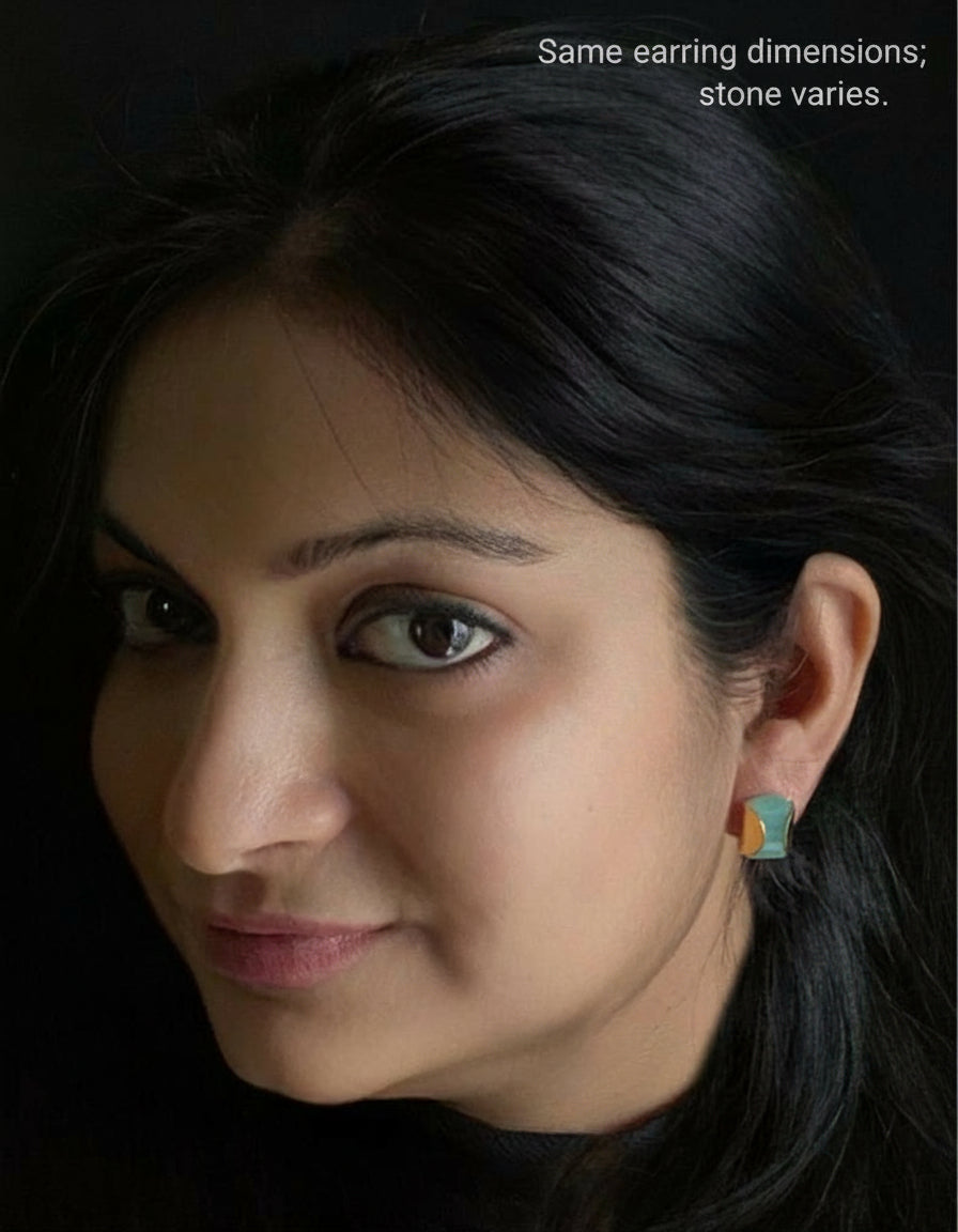 Lapis lazuli stud earrings in yellow-gold plated 92.5 sterling silver worn by a woman, showing their sleek, professional look when styled.