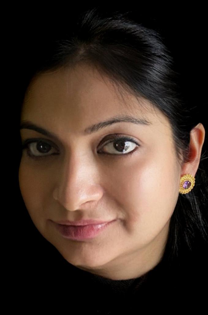 Amethyst and white topaz earrings in gold-plated 92.5 sterling silver worn by a woman, showing their cosmic-inspired sparkle when styled.