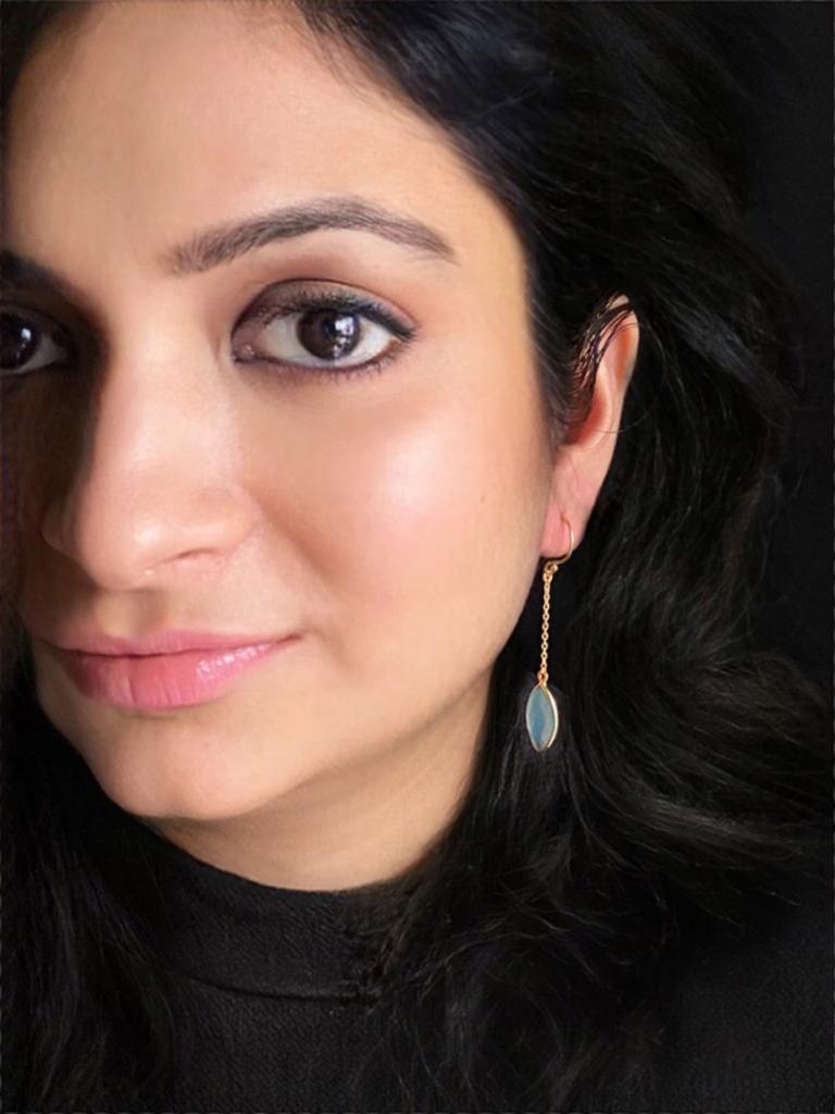 Aqua chalcedony earrings in gold-plated 92.5 sterling silver worn by a woman, showing their elegant ocean-inspired look when styled.