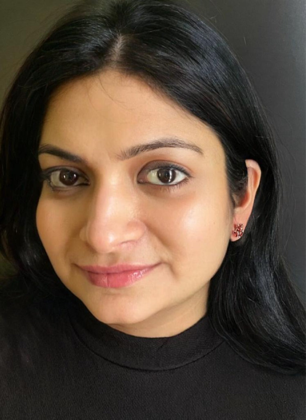 Garnet gemstone earrings in rhodium-finished 92.5 sterling silver worn by a woman, showing their vibrant, elegant look when styled.