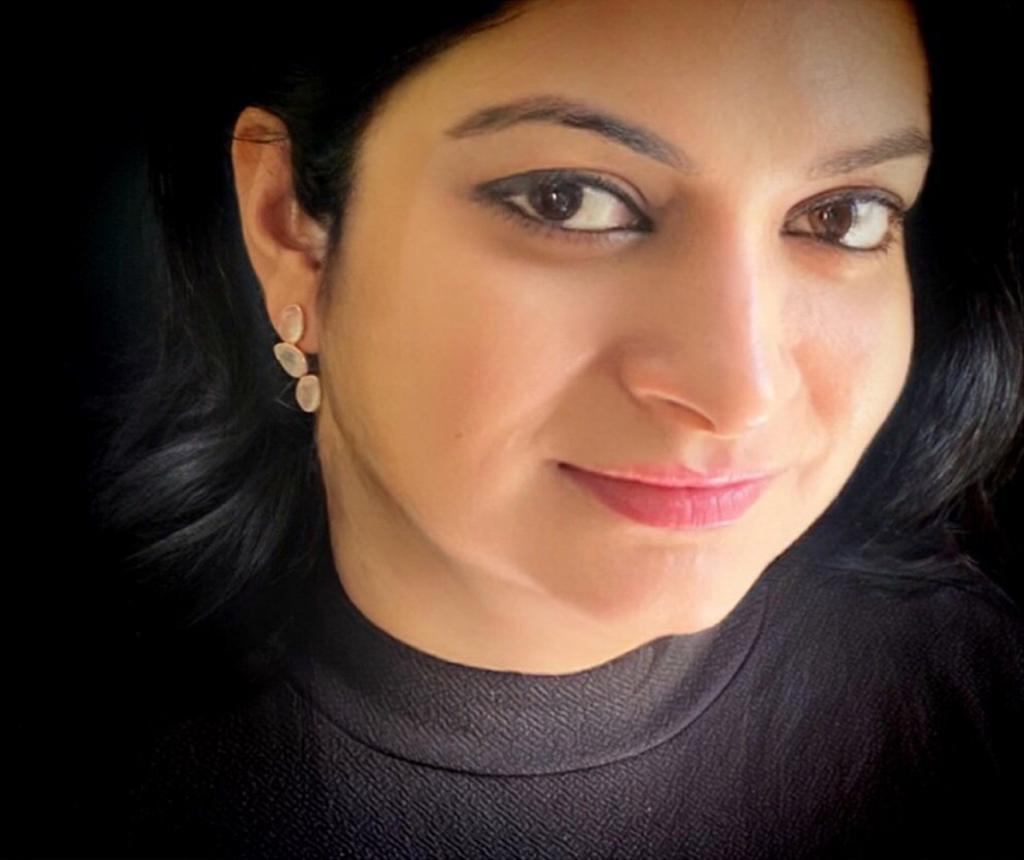 Rose quartz earrings in rose-gold plated 92.5 sterling silver worn by a woman, showing their soft, elegant lotus-inspired look when styled.